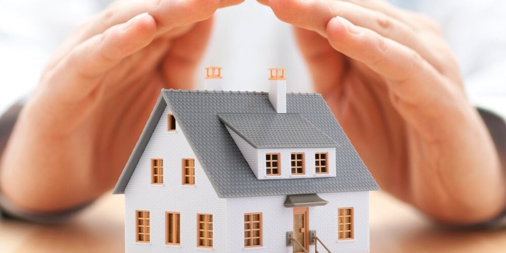 Protecting you home Home shielded by two hands